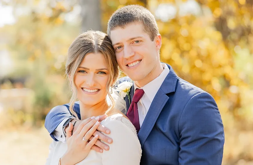 Reeann and her husband smile at the camera on their wedding day.